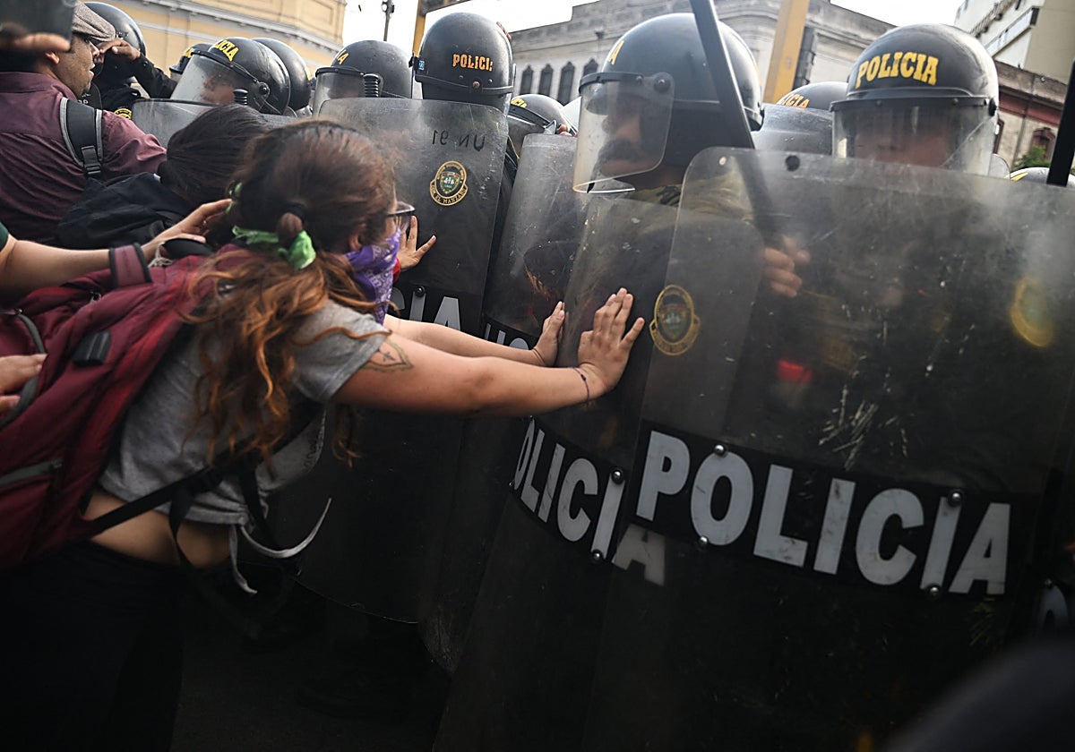 Una mujer protesta ante un grupo de policías por el desalojo de la principal universidad de Lima