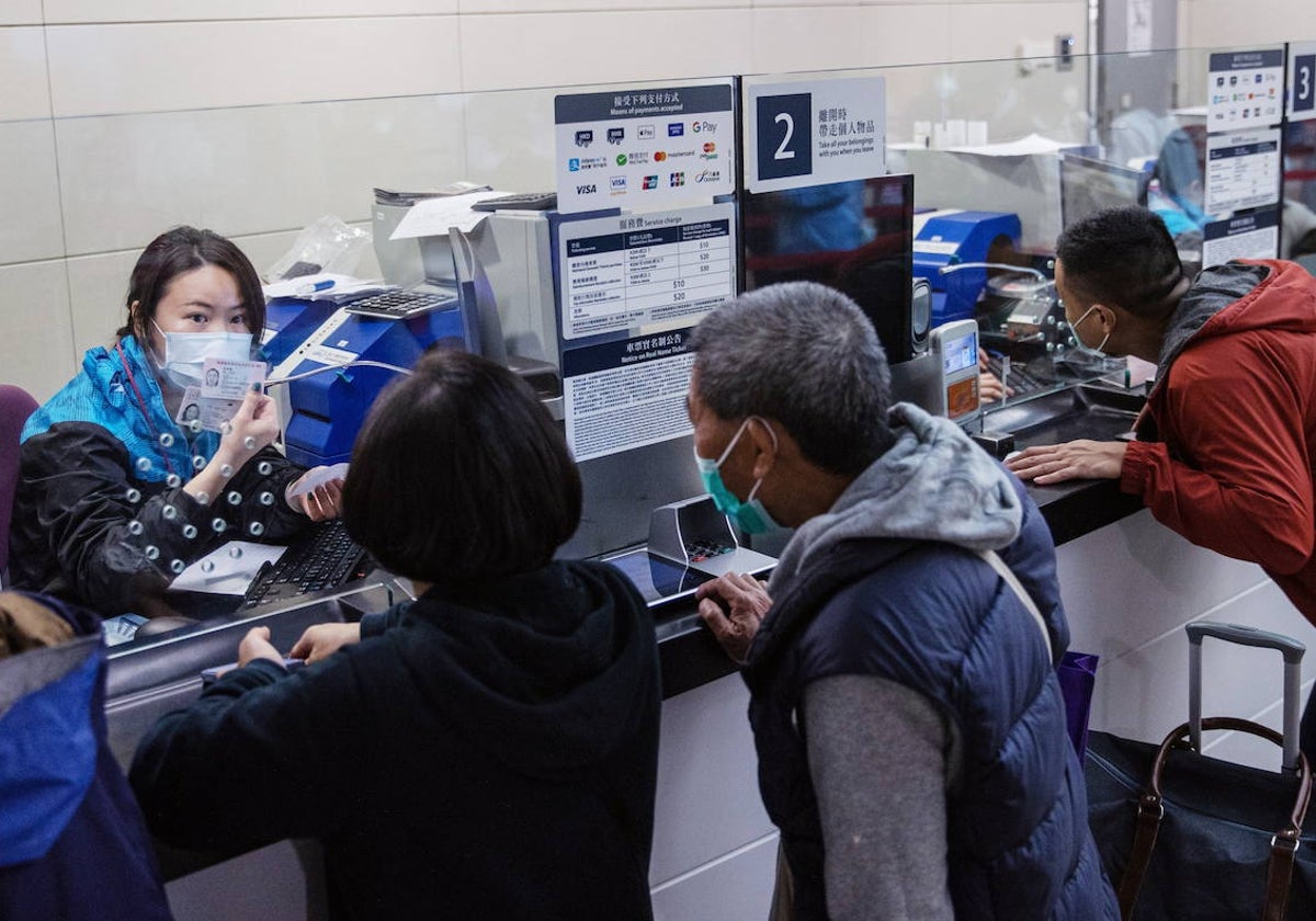 Varios turistas compran billetes para regresar a China desde la estación de trenes de Hong Kong