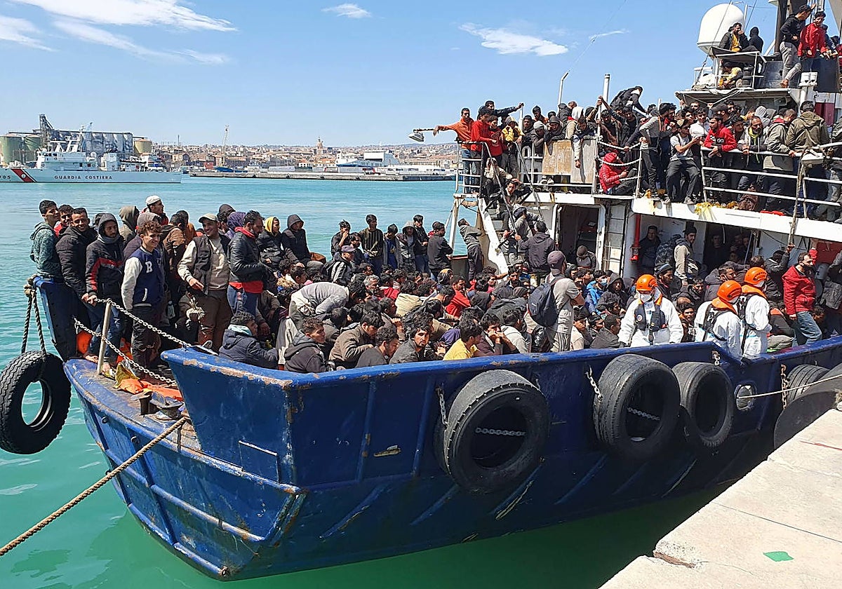 Inmigrantes rescatados y escoltados por la Guardia Costera llegan en barco al puerto de Catania, en Sicilia