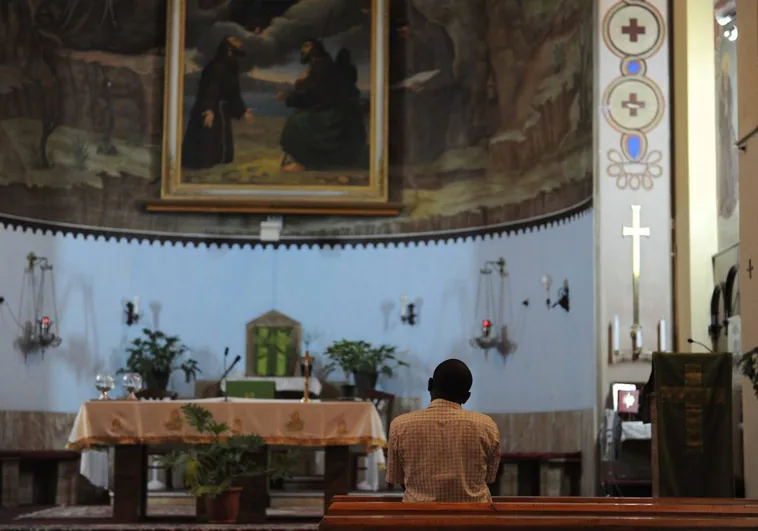 Un hombre reza en el interior de una iglesia de Trípoli