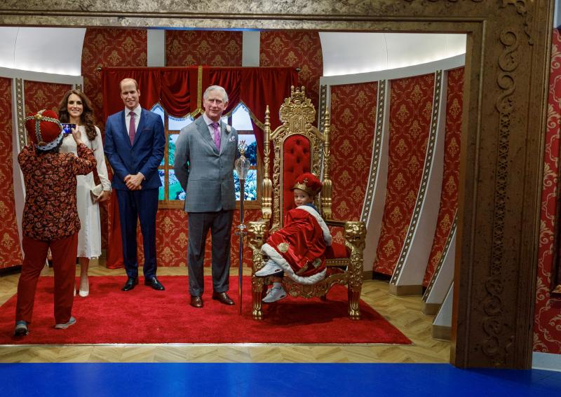 Un visitante toma fotos de las figuras de cera recién reveladas del rey Carlos, el príncipe Guillermo y Catalina, princesa de Gales, antes de la coronación del rey Carlos, en el museo Madame Tussauds.