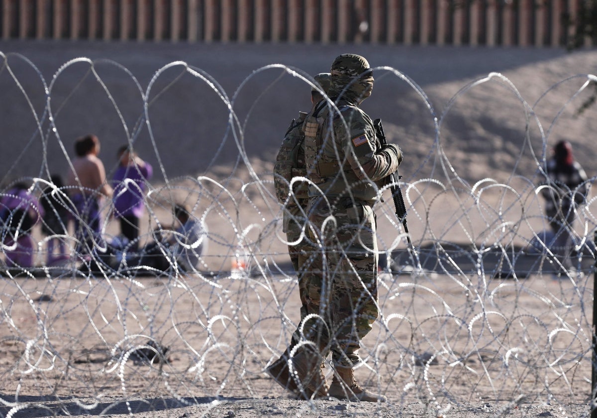 Miembros de la Guardia Nacional de EE.UU. patrullan mientras los migrantes esperan a orillas del Río Grande para ser procesados por la Patrulla Fronteriza de El Paso