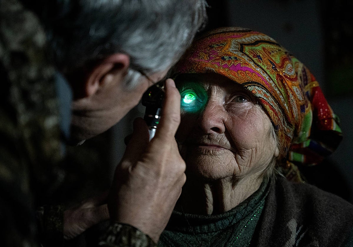 Olga, una vecina anciana de Sviato-Pokrovske, durante la exploración ocular del doctor Michael Smith, en una visita domiciliaria al frente ucraniano