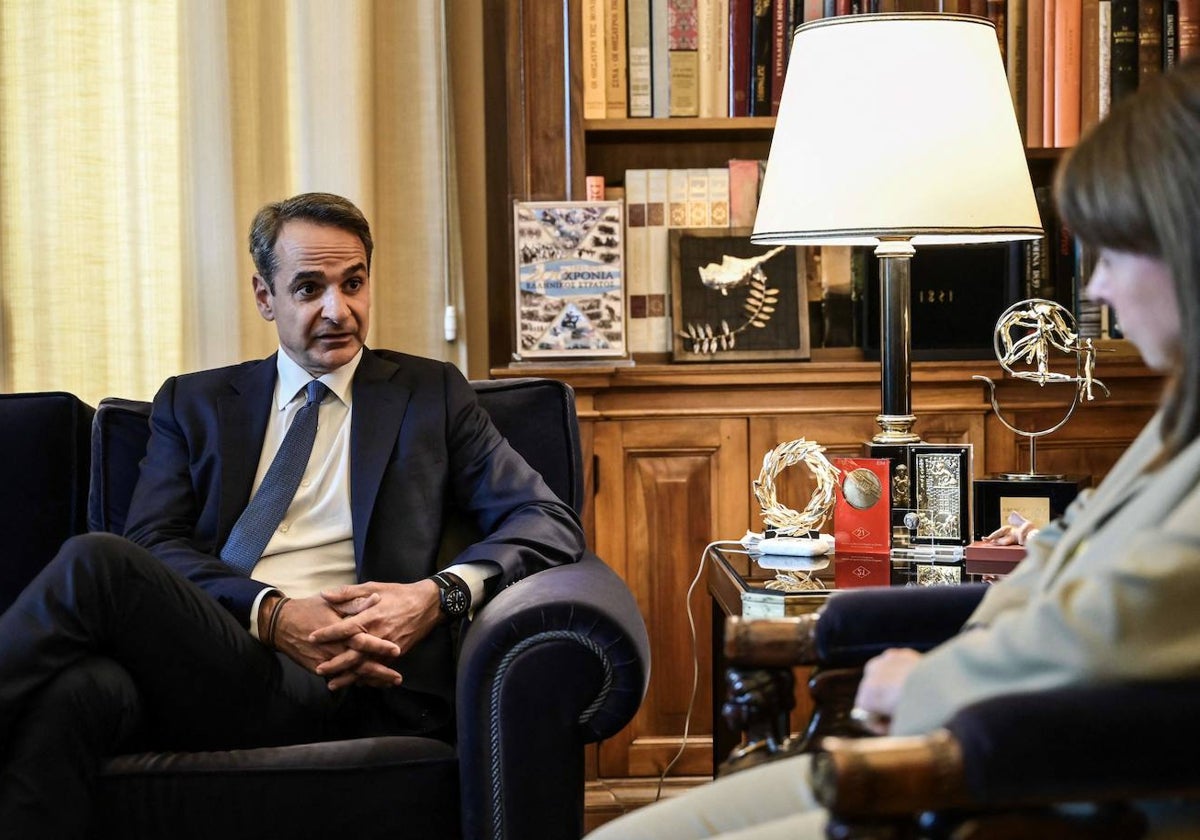 El primer ministro griego, Kyriakos Mitsotakis, habla con la presidenta griega, Katerina Sakellaropoulou, antes de su reunión en el Palacio Presidencial de Atenas