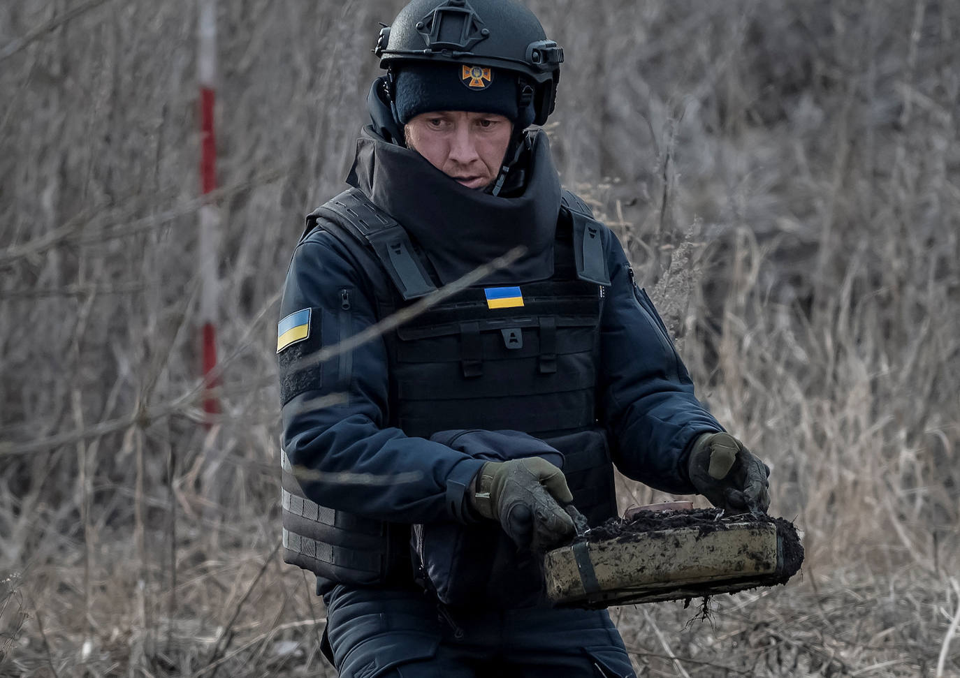 Un zapador del Servicio de Emergencia del Estado saca una mina antitanque mientras inspecciona un área en busca de minas y proyectiles sin explotar en la región de Jarkov