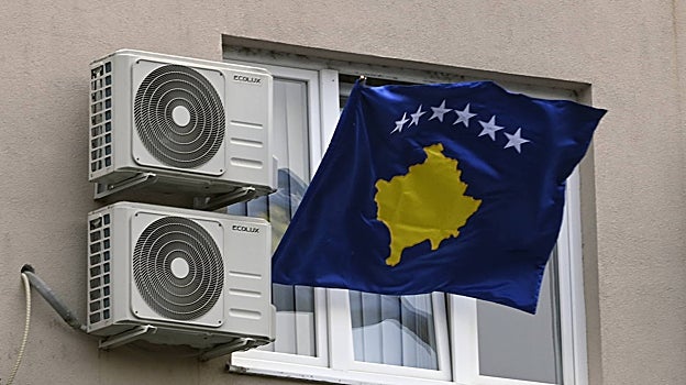 Una ventana en el norte de Kosovo, con la bandera nacional