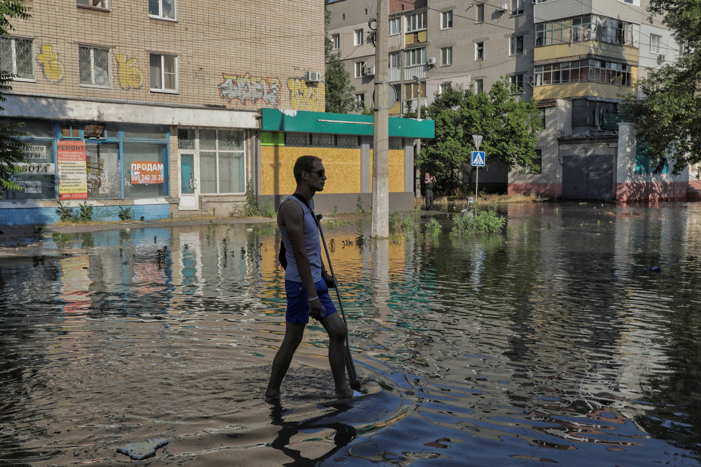 Un residente local camina por una calle inundada 