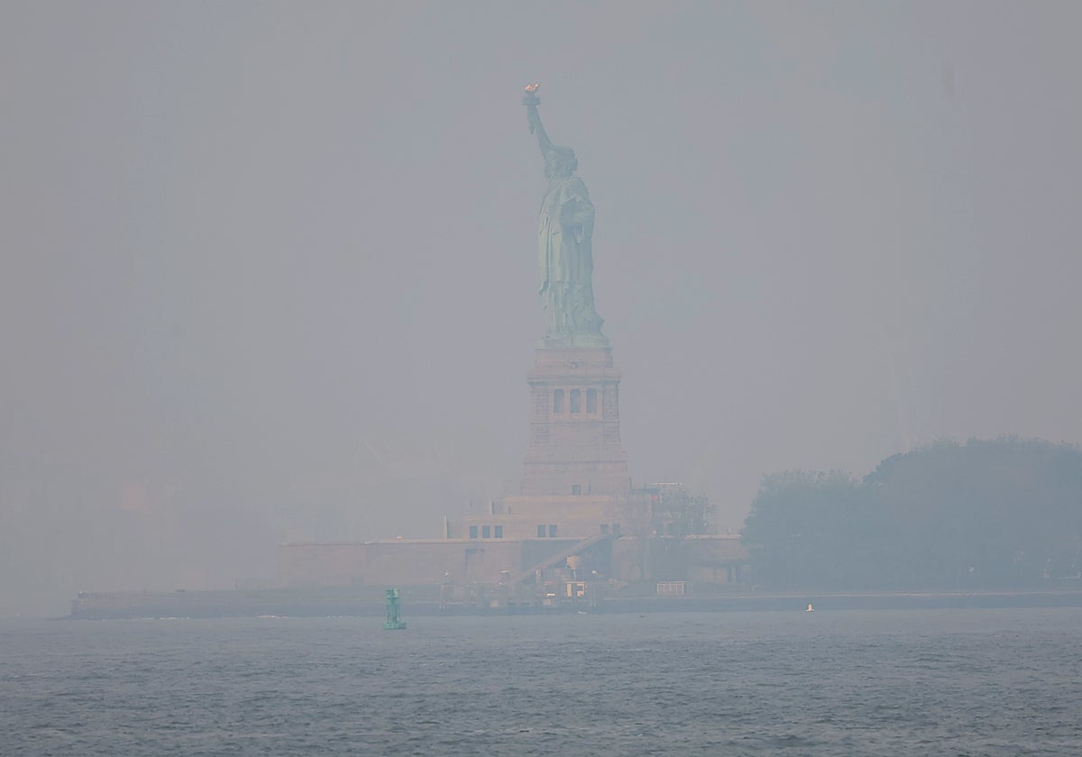 La estatua de la libertad, ayer naranja, hoy se encuentra cubierta por una densa neblina