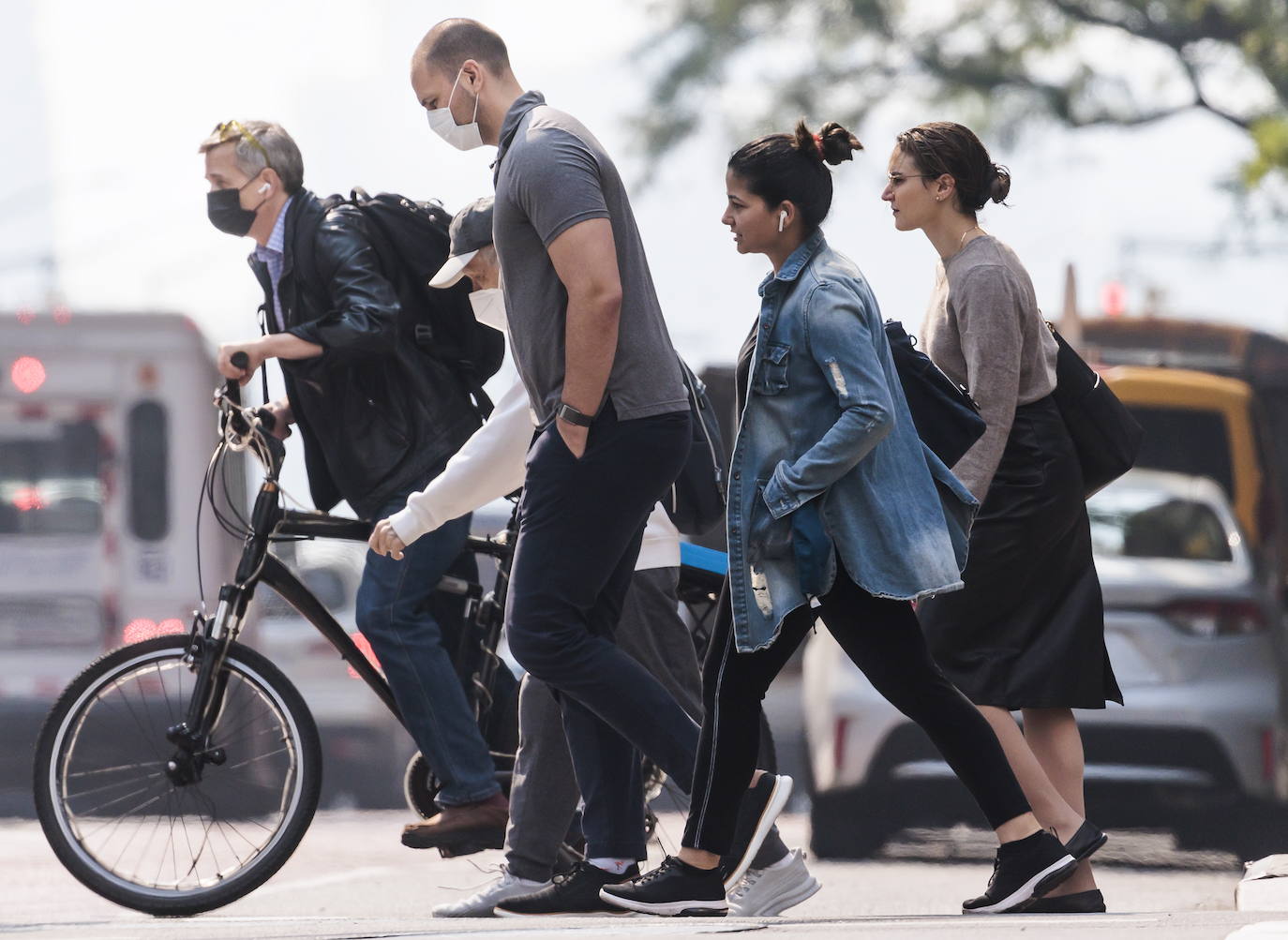 Gente cruza la calle 42, algunos con mascarillas por la mala calidad del aire