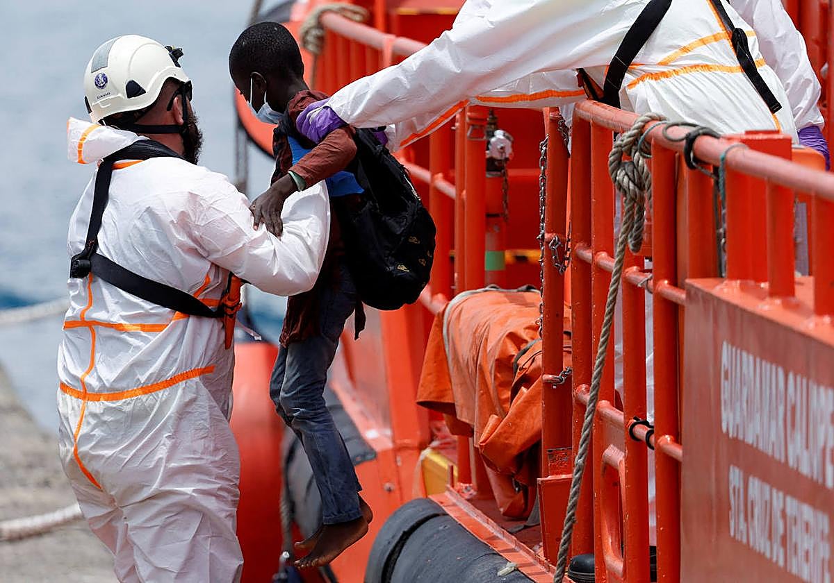 Un rescatista ayuda a un niño inmigrante a desembarcar en Arguineguín, Gran Canaria