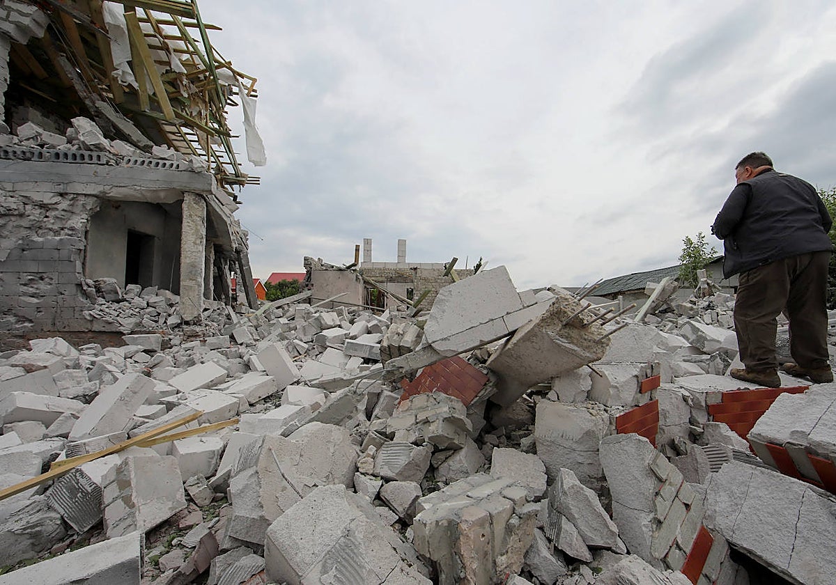 El hombre se encuentra sobre los escombros de un edificio gravemente dañado por un ataque militar ruso en la región de Jarkov