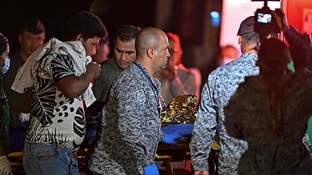 Manuel Ranoque cogiendo la camilla de uno de sus hijos tras ser rescatados