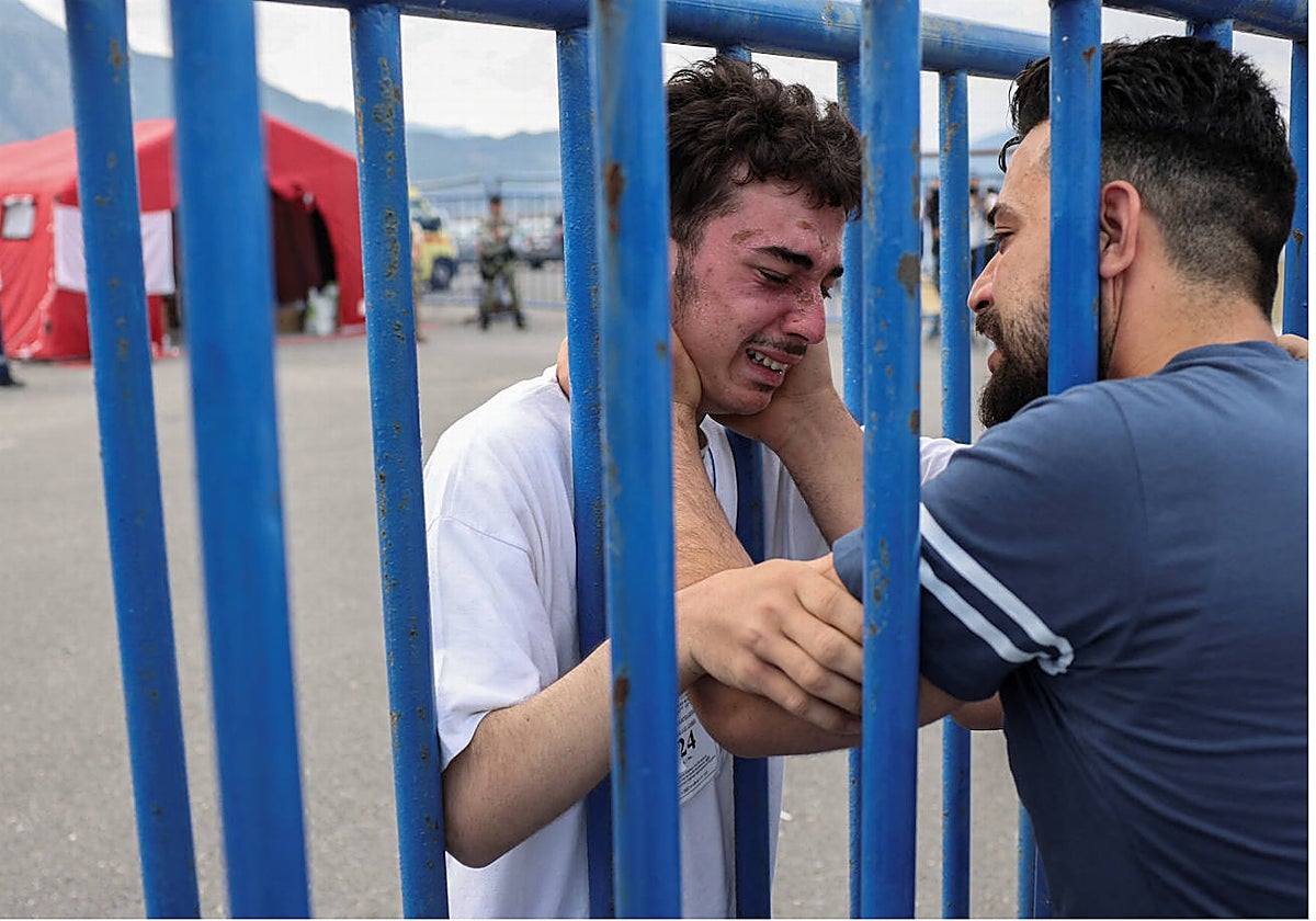 Mohamed (de blanco) llora al reencontrase con su hermano mayor Fathi en Kalamat