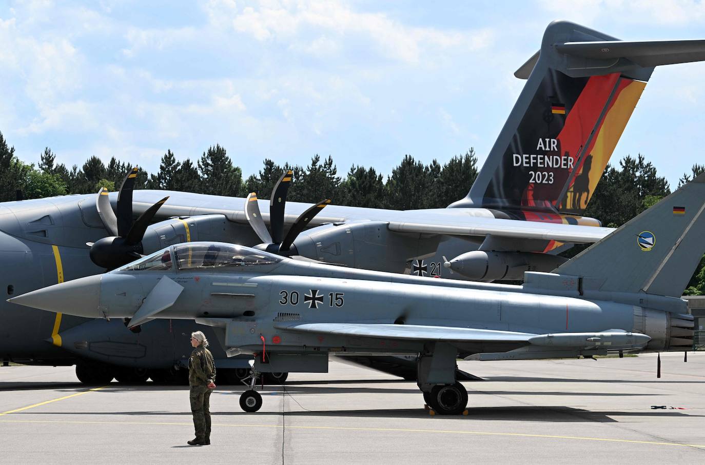 Un soldado de las Fuerzas Armadas Alemanas Bundeswehr junto a un avión de transporte Airbus A400M y un Eurofighter durante el ejercicio Air Defender 2023 en la base aérea militar de Lechfeld