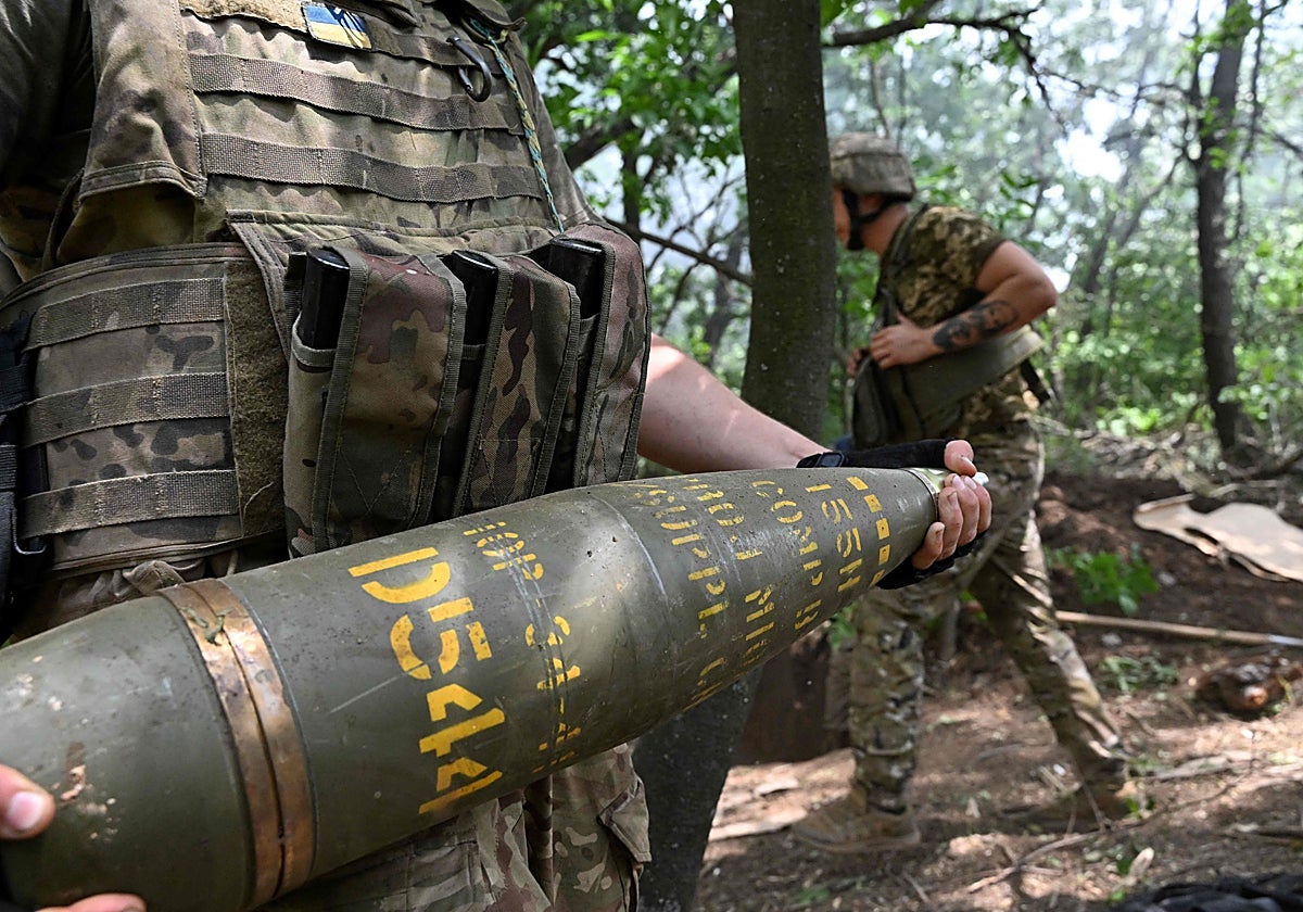 Un artillero ucraniano lleva un proyectil de 155 mm para disparar un obús M777 hacia posiciones rusas cerca de Avdiivka, en la región de Donetsk