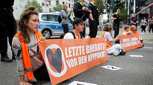 Varios jóvenes sentados en el asfalto cortan el tráfico