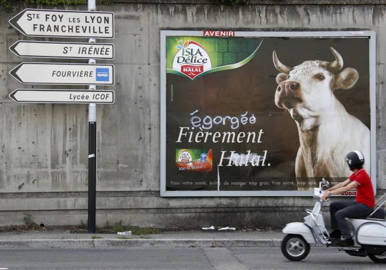 Un motorista, ante una valla de carne halal para protestar contra la matanza de animales en Lyon