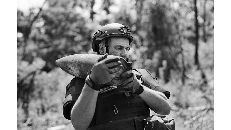 Mykhaylo transporta un obús ruso sin estallar de una antigua posición rusa en el este de Ucrania.