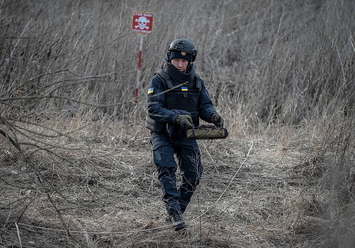 Un soldado ucraniano porta una mina tras desactivarla