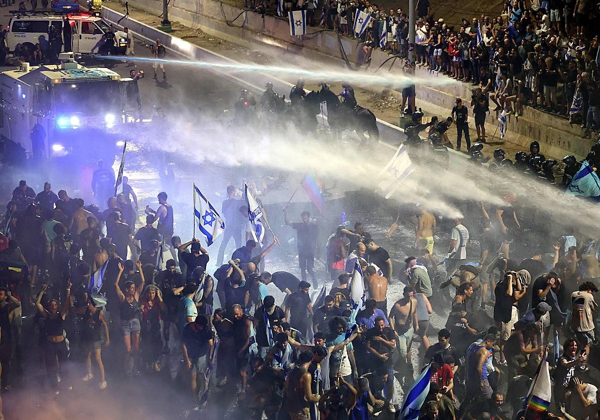 Manifestantes son rociados con cañones de agua por la policía antidisturbios israelí en Tel Aviv