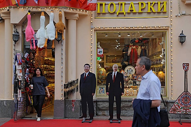 Fuera de una tienda de regalos en Moscú, se ven figuras de cartón que muestran imágenes de Putin y de Xi Jinping