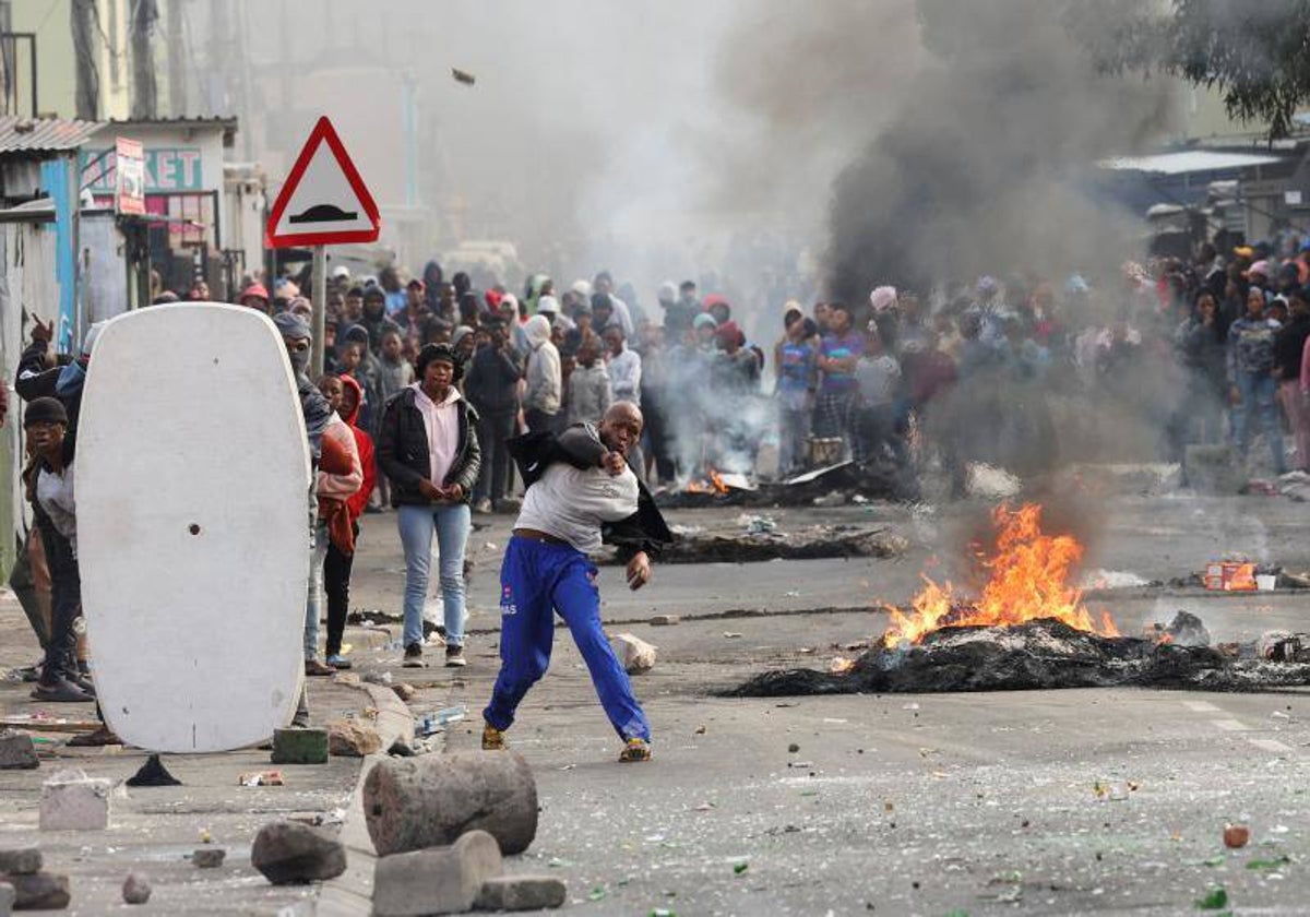 Manifestantes, tirando piedras contra la policía durante los disturbios