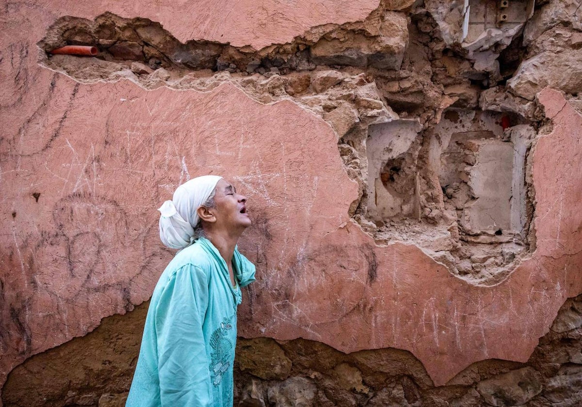 Una mujer reacciona frente a su casa dañada por el terremoto en Marrakech