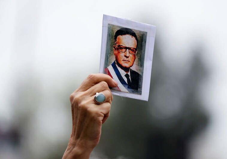 Una persona sostiene un retrato con el rostro de Salvador Allende en Santiago de Chile