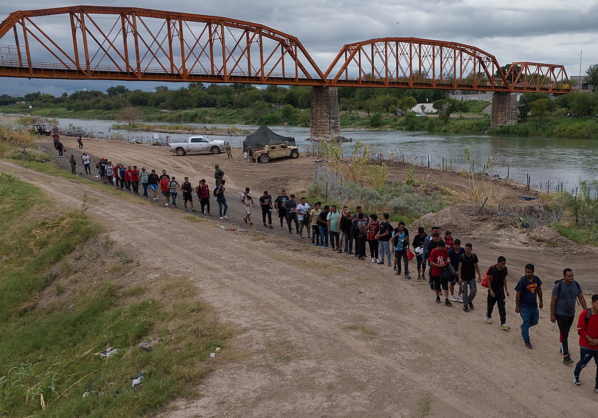 Inmigrantes, la mayoría venezolanos, pasa bajo el Puente Negro tras cruzar el Río Grande