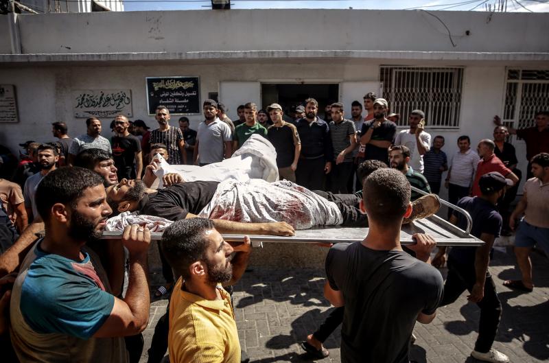 Palestinos transportan el cuerpo de un combatiente muerto durante el asalto a Israel, en la ciudad de Gaza