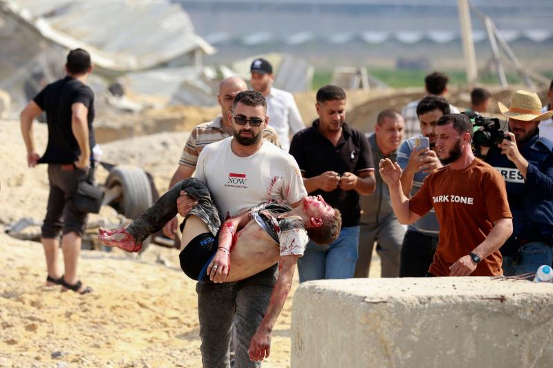 Un hombre se lleva a un palestino muerto en un ataque aéreo israelí en el cruce de Erez entre Israel y el norte de la Franja de Gaza