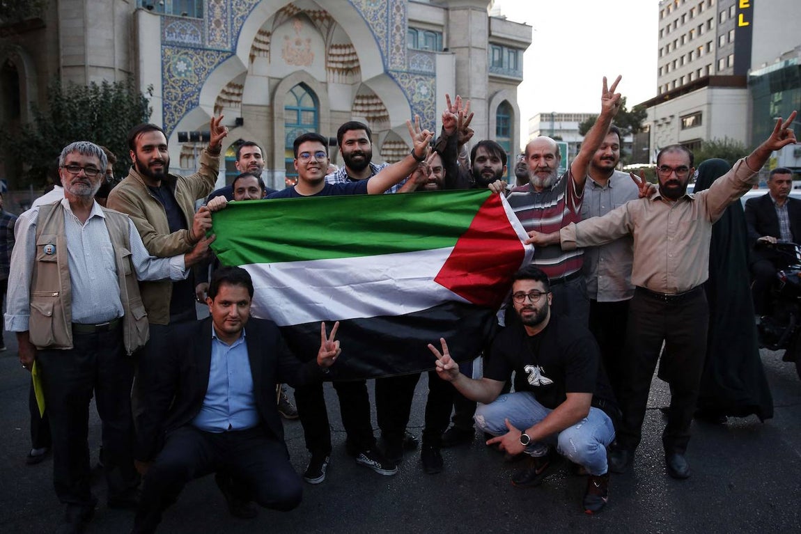 Un grupo de iraníes sostiene una bandera palestina para expresar su respaldo a los terroristas de Hamás tras los ataques perpetrados contra Israel, que han supuesto la muerte de cientos de personas y han dejado a miles heridas.