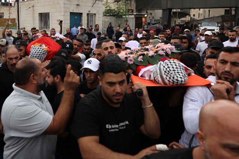 Los palestinos cargan los cuerpos de Yasser Kusba, de 18 años, y Adam Julani, de 16, muertos en enfrentamientos con soldados israelíes