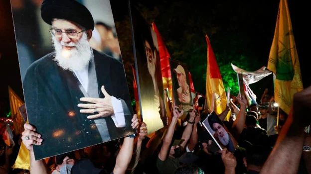 Los iraquíes sostienen un retrato del líder supremo de Irán, el ayatolá Ali Jamenei, y gritan consignas durante una manifestación