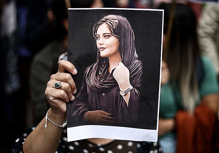 Una mujer sostiene una fotografía de Mahsa Amini en una protesta en Bruselas