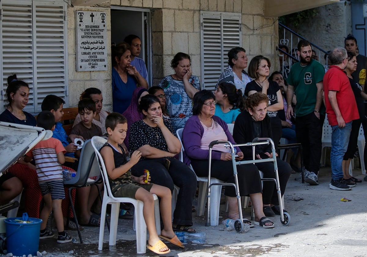 Familias cristianas palestinas se reúnen en torno a la iglesia ortodoxa griega de San Porfirio tras el ataque aéreo que dejó 16 muertos