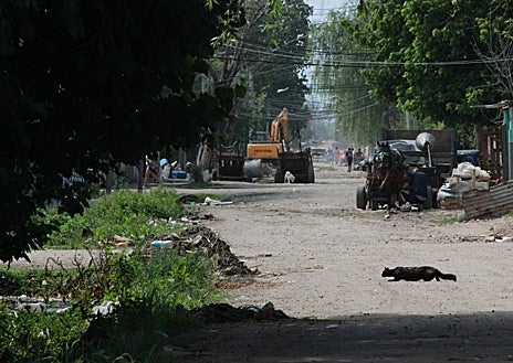 Imagen secundaria 1 - Arriba, María Rosa Díaz charla con una vecina. Abajo, calles del barrio