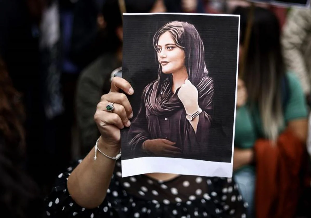 Un manifestante sostiene un retrato de Mahsa Amini durante una manifestación en su apoyo