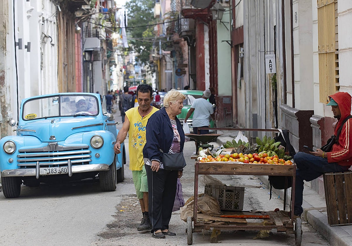 Una mujer mira los productos de un puesto de comida ambulante en La Habana