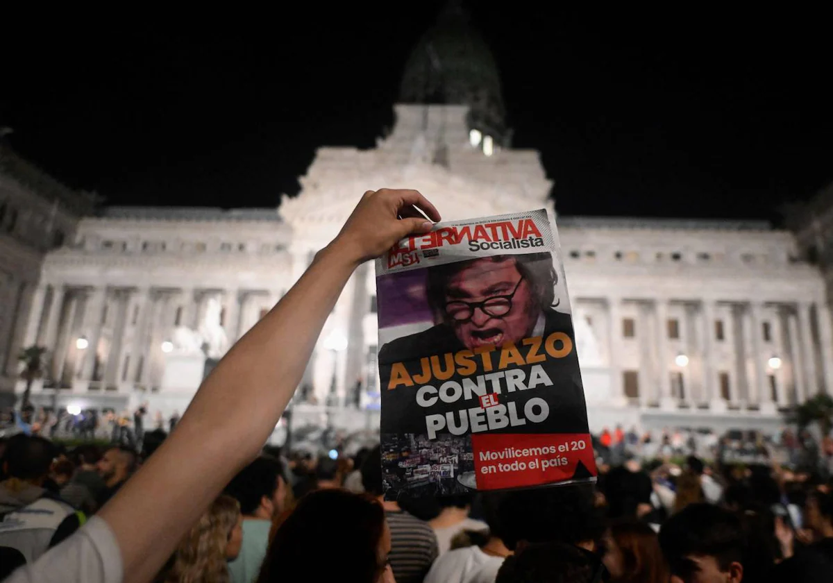 Un hombre muestra un periódico durante una manifestación contra el nuevo gobierno del presidente argentino Javier Milei frente al Congreso Nacional , en Buenos Aires