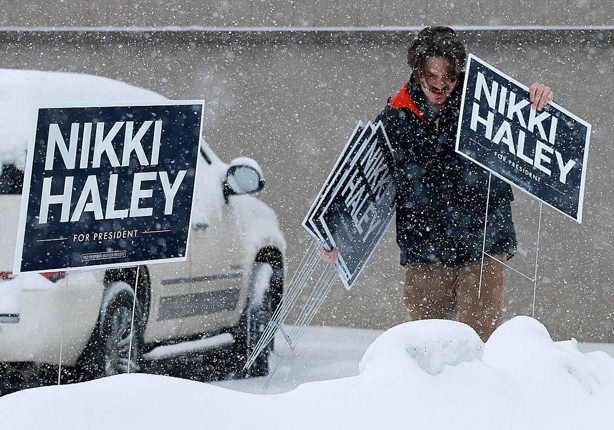 Un hombre pone carteles a favor de Nikki Haley en iowa