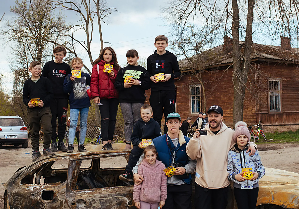 Los dos jóvenes con los niños y sus cámaras de usar y tirar