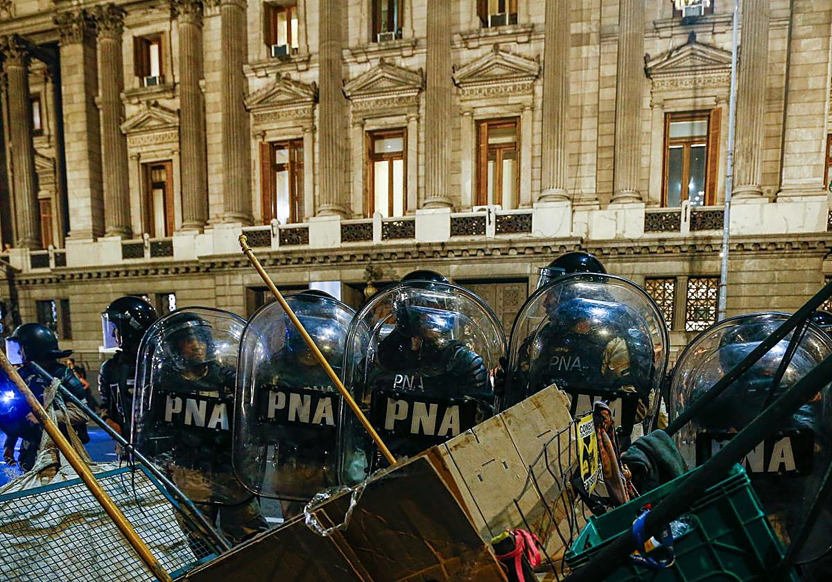 Policías hacen presencia durante una protesta de manifestantes contra el proyecto de 'ley ómnibus' en las inmediaciones del Congreso
