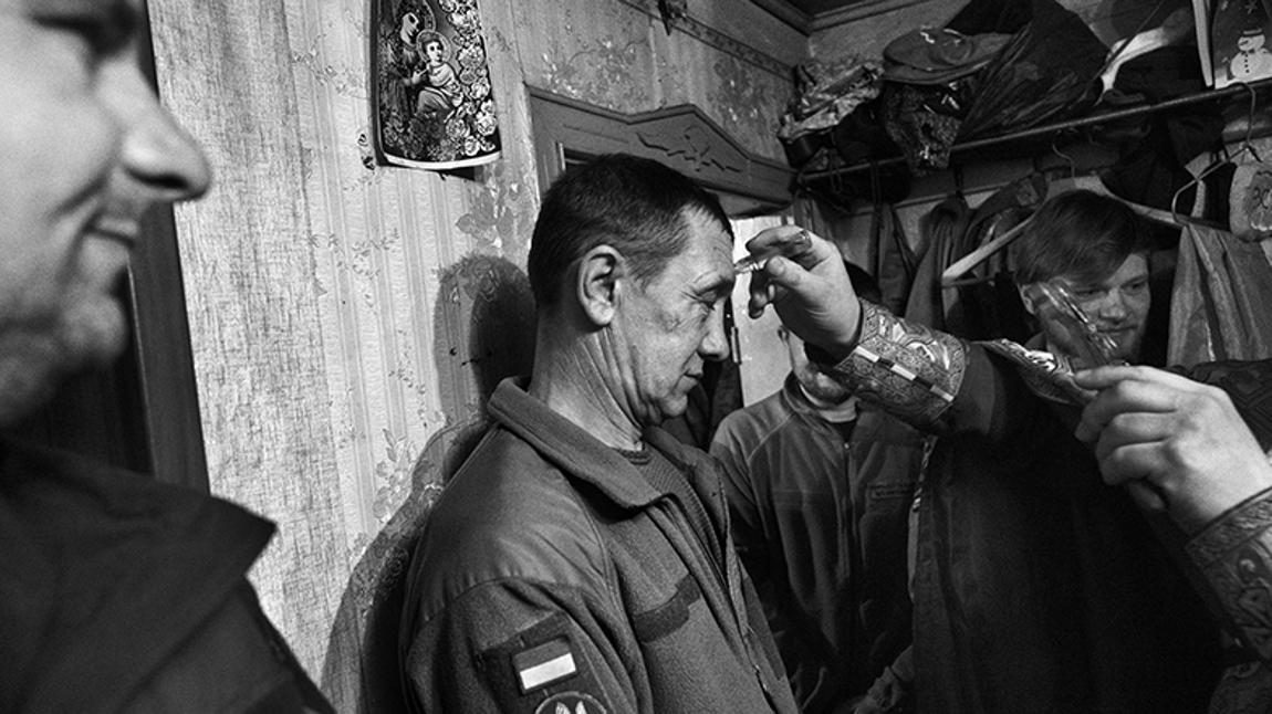 Chasiv Yar - Donestk: el Padre Ivan durante la celebración de la Santa Misa en el interior de una base de una unidad de la Brigada 80 en el frente de Bakhmut bendice y da la unción con óleo a los soldados