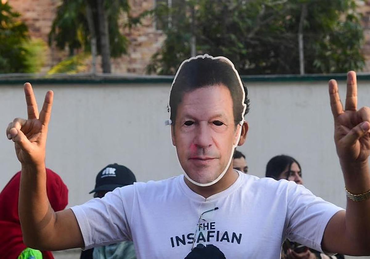 El partidario del partido Pakistan Tehreek-e-Insaf (PTI) de Imran Khan usa la máscara de Khan