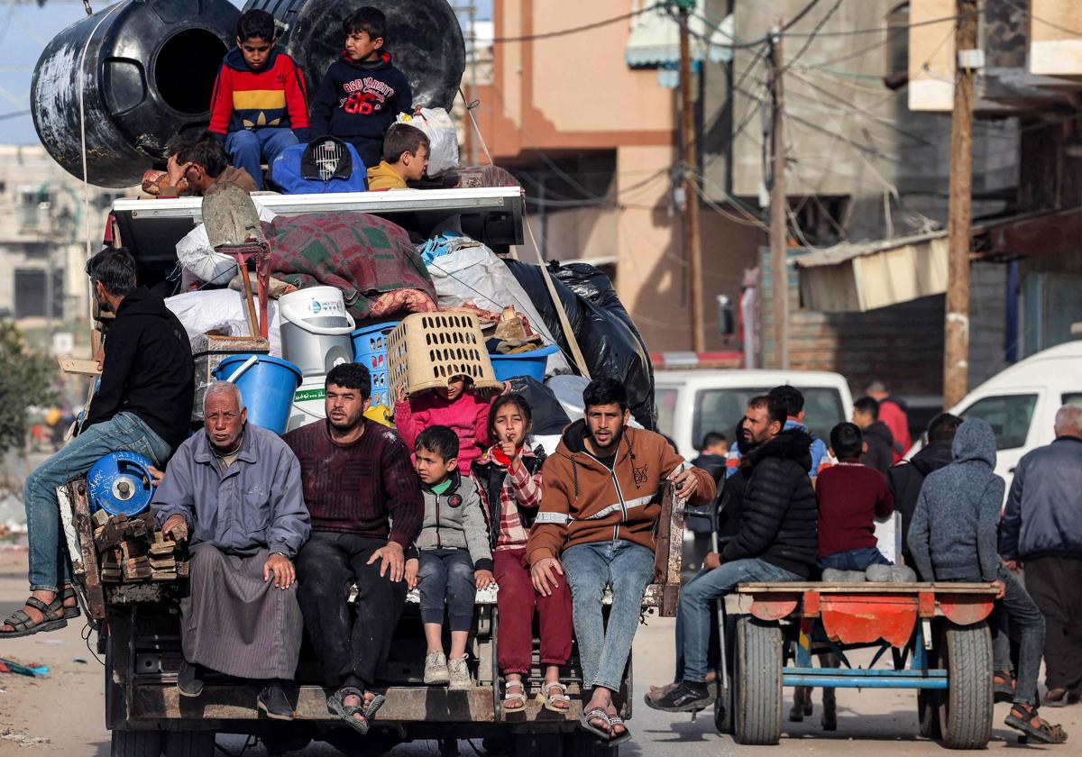 Varios miembros de una familia palestina huyendo de Rafah en un camión con sus pertenencias