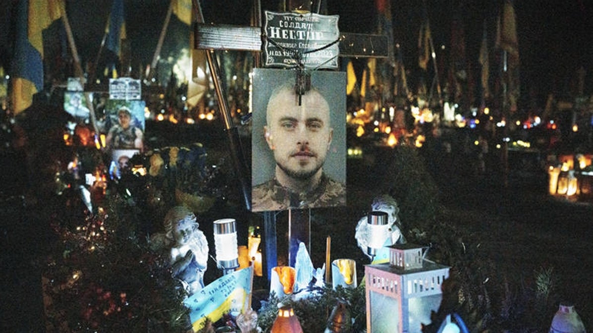Leópolis (Ucrania). La tumba de un soldado Ucraniano fallecido en combate decorada con velas y luces en el interior del cementerio militar de Leópolis