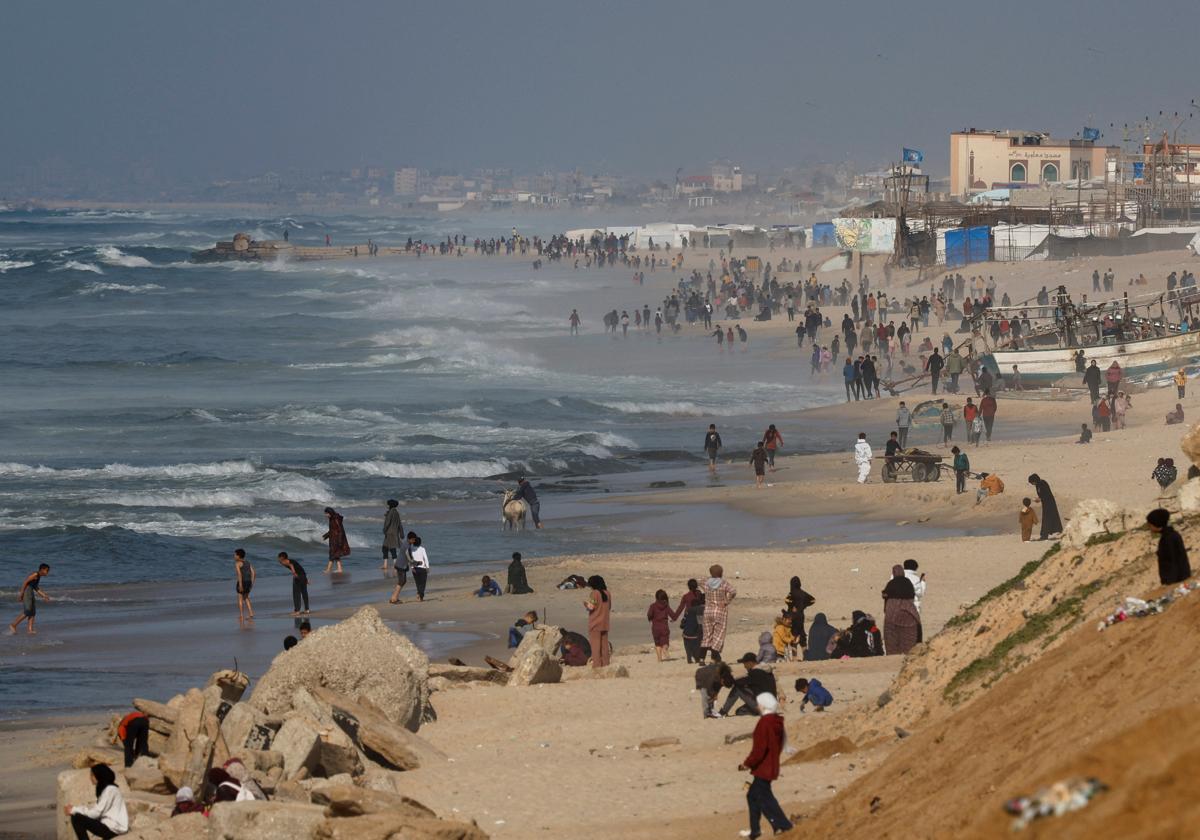 Personas en Gaza esperan en la playa la llegada de ayuda humanitaria