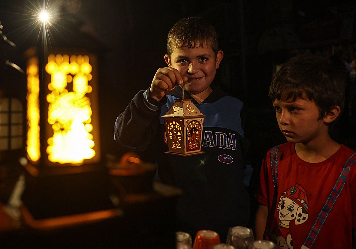 Un grupo de niños palestinos sostiene las lámparas tradicionales que se usan en los días previos al ramadán
