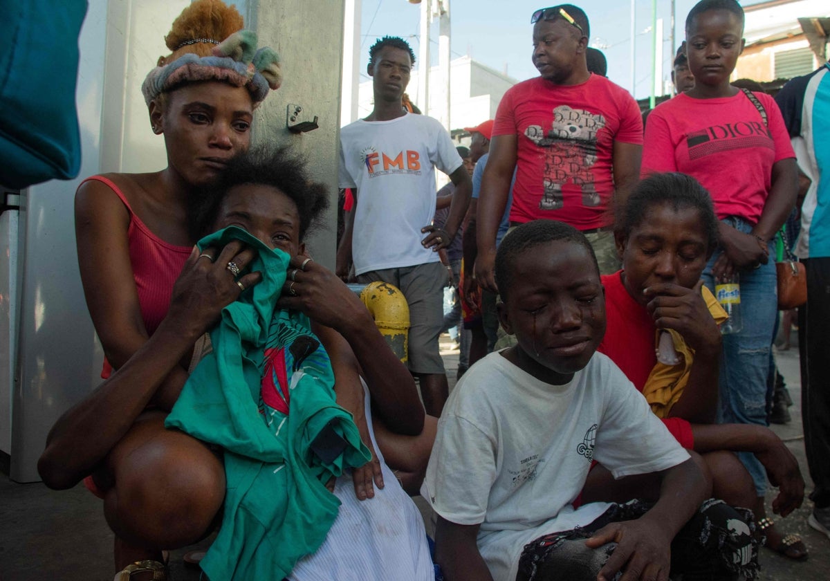 Varias personas lloran después de que una docena fueran asesinadas en la calle por pandilleros, en Pétionville, Puerto Príncipe, Haití,